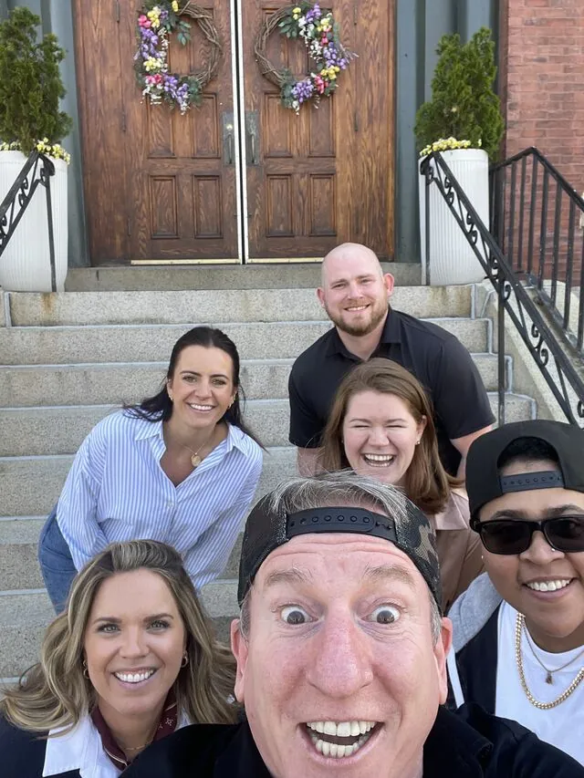 Five colleagues on the steps of a Salem townhouse during the scavenger hunt